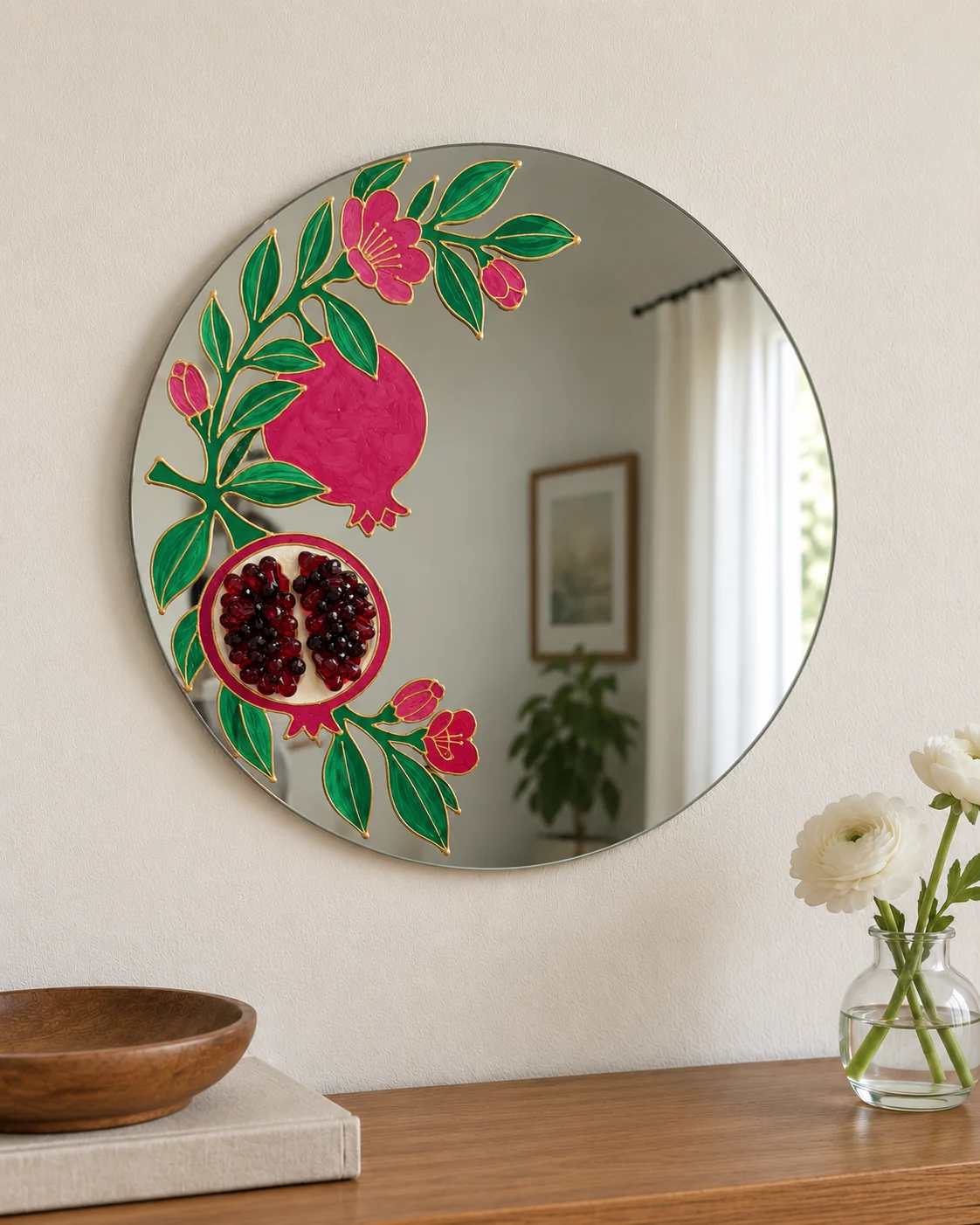 Pomegranate mirror hanging on a light wall above a wooden console